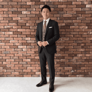 会社の同僚の結婚式　職場の仲間として恥ずかしくない、ブラックシャドーストライプスーツを着た男性