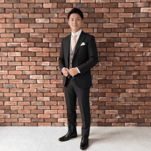 友人の結婚式に参列し乾杯の挨拶をする男性のコーディネート